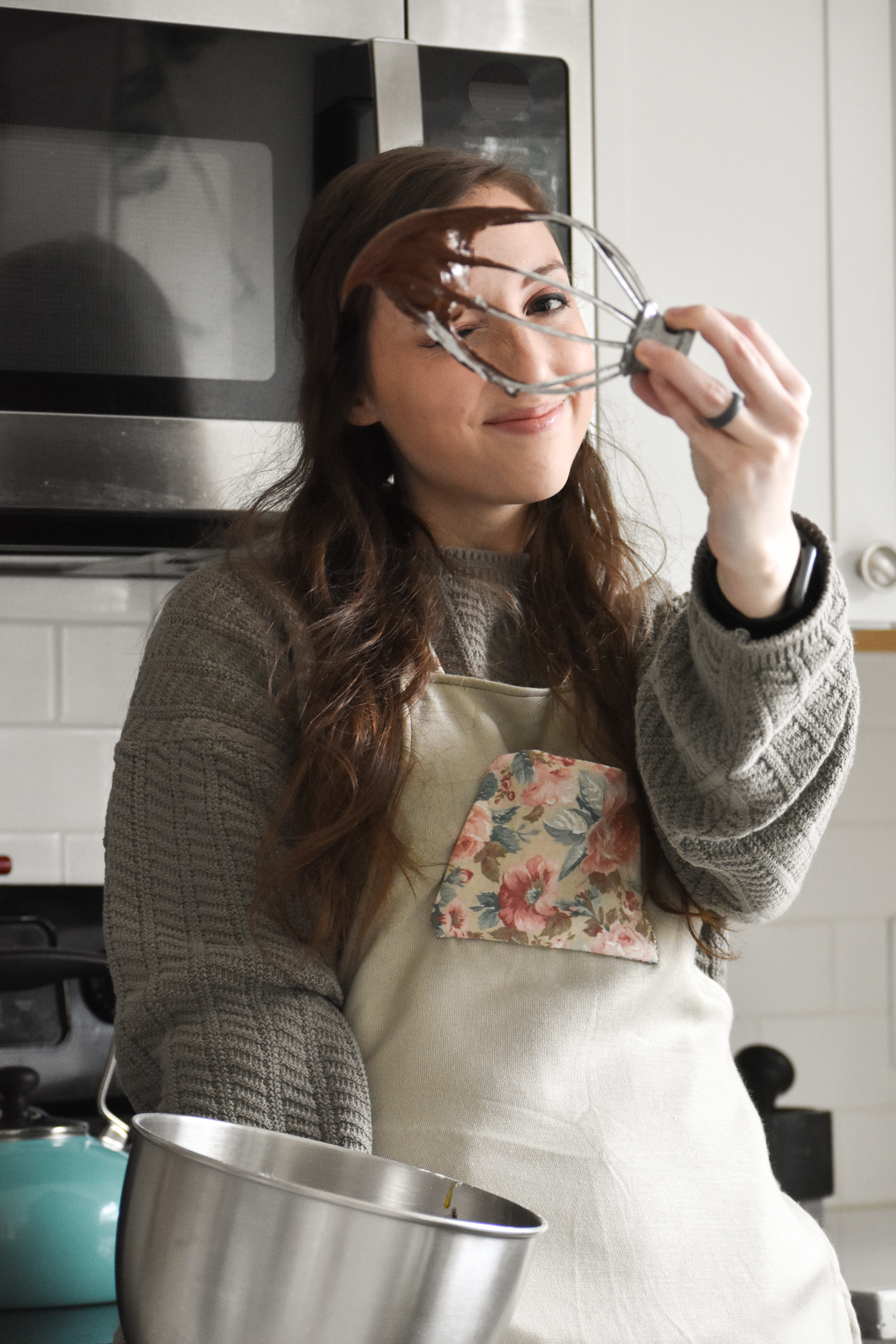 Founder Brittany Male holding a beater with batter dripping from it.